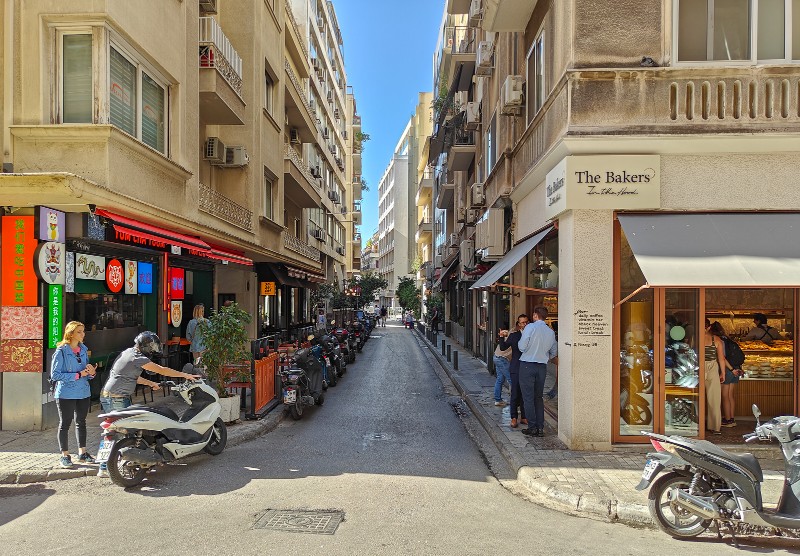 Nikis Street in central Athens with cafés, bakeries, and locals enjoying coffee near Syntagma Square.