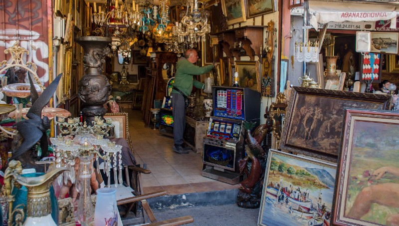 Antique shop filled with chandeliers, paintings, and curios at Avissinias Square in Monastiraki Athens