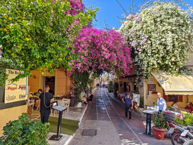 Photo cornenrs in the Plaka neighborhood in Athens - Bougainvillea arch over a narrow café-lined street on Lysiou in Plaka, Athens.