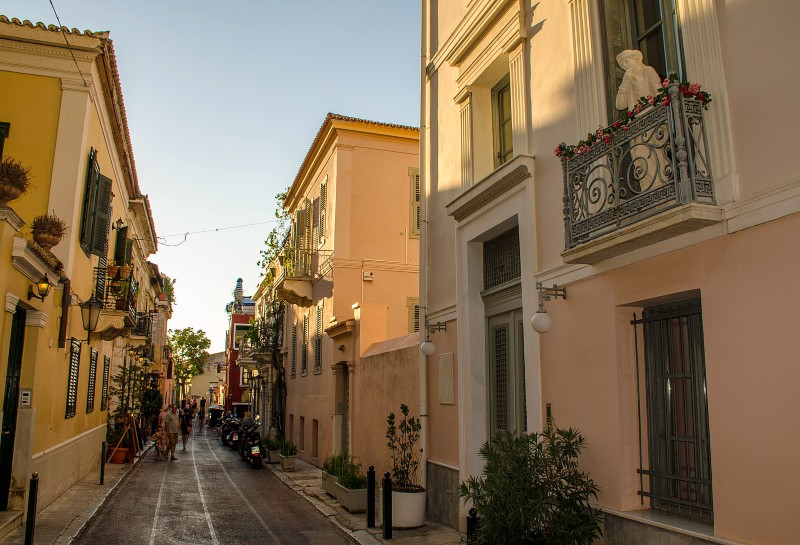 Neoclassical lane in Plaka, Athens, with balconies and warm evening light.