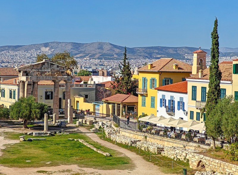 Colorful Plaka houses and café terraces beside the Roman Agora and the Gate of Athena Archegetis.