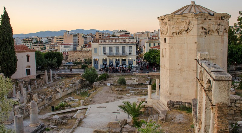 Octagonal Tower of the Winds beside the Roman Agora ruins in Athens at sunset.