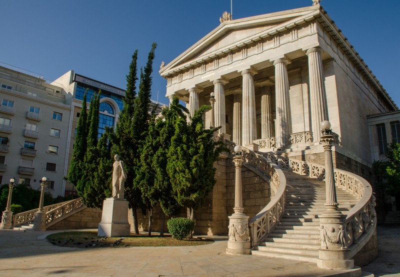 Discover Athens’ neoclassical Trilogy — the National Library, University, and Academy — glowing at sunset in timeless elegance.
