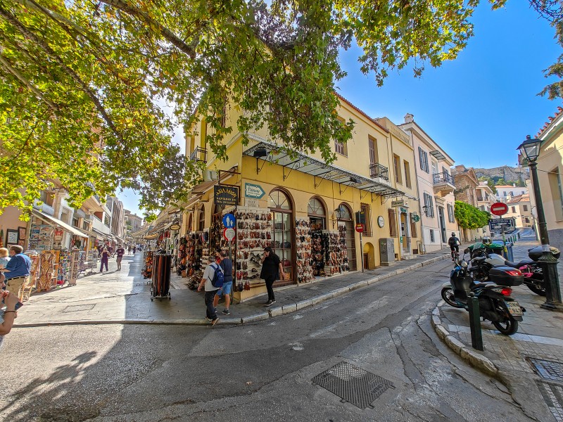 Street corner in Plaka Athens with souvenir shops, neoclassical buildings, and access to nearby hotels